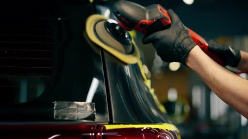 Nahaufnahme der Fahrzeugdetails an einer Tankstelle Das schwarze Auto ist mit gelbem Klebeband bedeckt, der Vorgang von