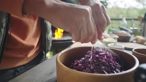 Mann fügt geschreddertem Rotkohl Zitronensaft hinzu