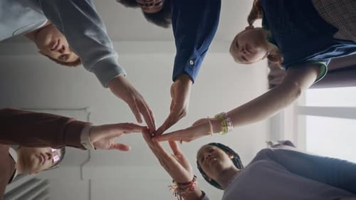 Young Adults Put Hands Together in Friendship