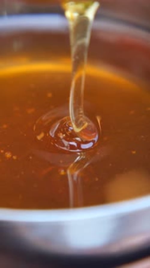 Sweet Honey Dripping From a Spoon in Kitchen
