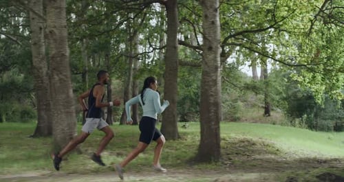 Active people jogging outdoors in a green forest on summer day