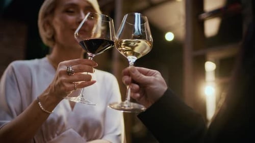 Des mains qui tintent dans des verres à vin dans un restaurant de luxe