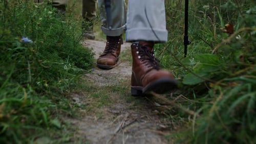 Hiking Boots Land on Ground Trail While Active Walkers Balance