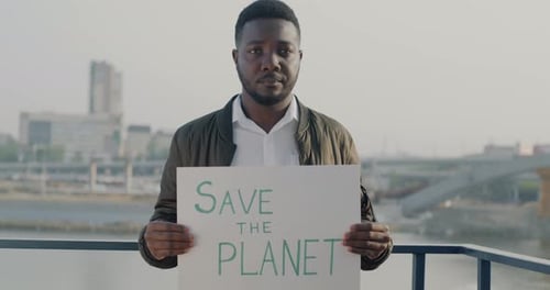 Man Holds Save the Planet Sign in City