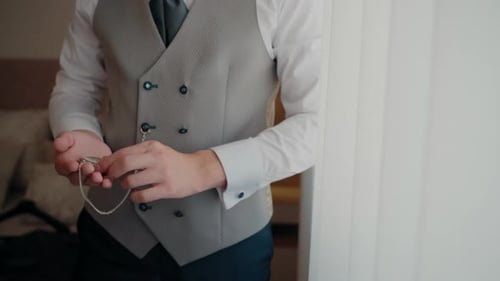 Man Puts Pocket Watch in Vest Pocket Indoors