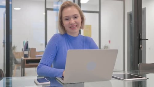 Young Woman Uses Laptop in Modern Office