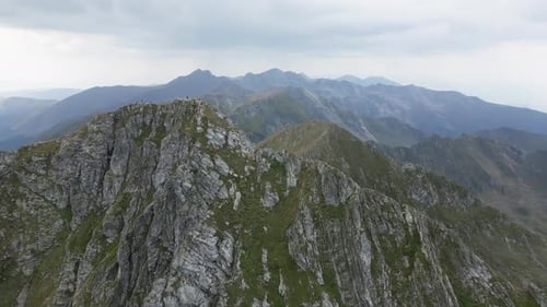 drone orbit around a mountain peak with mountains, a sea and beautiful landscape in the background,