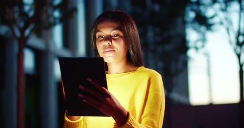 Woman Uses Tablet Outdoors at Night