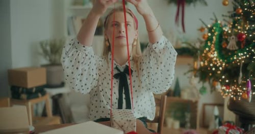 Young Woman Wrapping a Christmas Gift at Home
