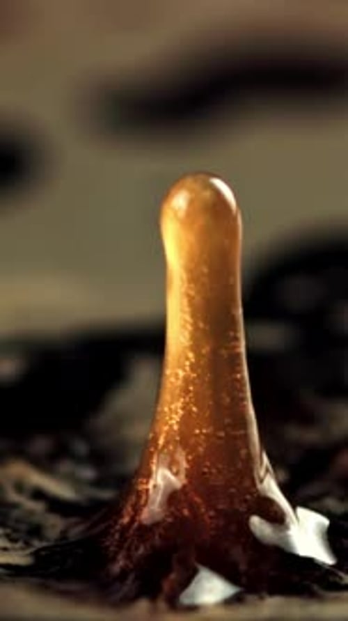A Drop of Spray Falls Into the Black Coffee Macro backgroundFilmed is Slow Motion 1000 Frames Per