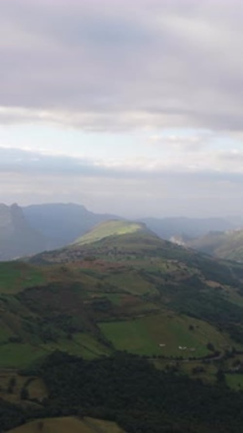 Scenic Aerial View of Rolling Green Hills and Mountains Vertical
