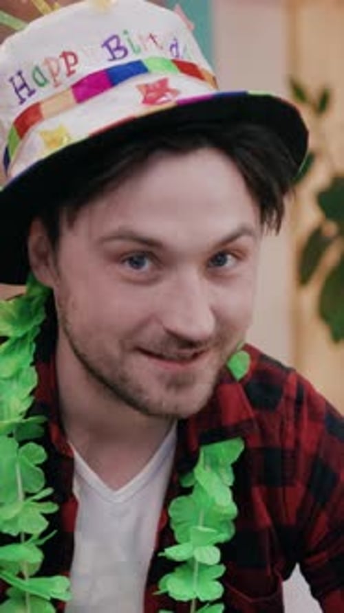 Joyful and Cheerful Birthday Celebration Adorned with a Party Hat and a Green Garland