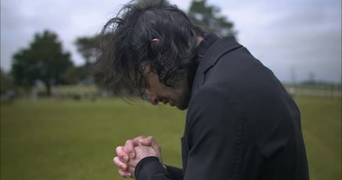 Trauriger Mann, der während der Beerdigung auf dem Friedhof trauert.