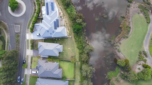 Drone aerial view of country club houses on golf course fairway with roads