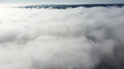 Mist fog clouds from above aerial view over seasonal autumn forest low morning sunlight