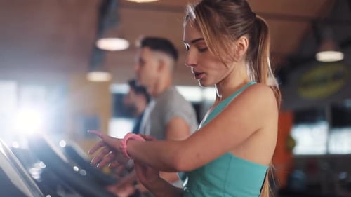 Beautiful Young Woman on Treadmill Use Smartwatch in Gym Light Sportsman Sport Fitness Internet Face