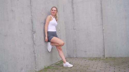 Active Young Woman Stretching Before a Run Outdoors