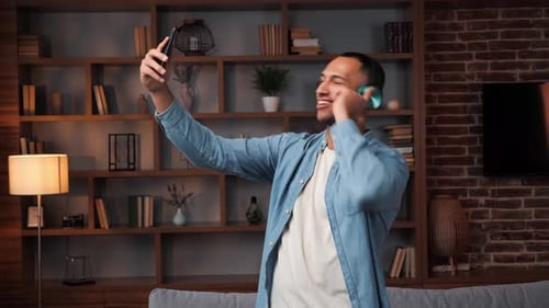 Smiling Man Dances While Recording Video on Phone