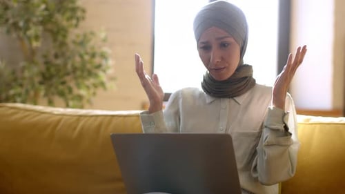 Worried Woman Using Laptop in Home Setting