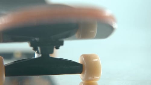 A beautiful detailed follow shot of a mini skateboard, tiny white wheels, fingerboard on a 360 rotat