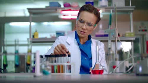 Científica que trabaja en el laboratorio. Cura científica. Una científica comprueba un tubo de ensayo con...