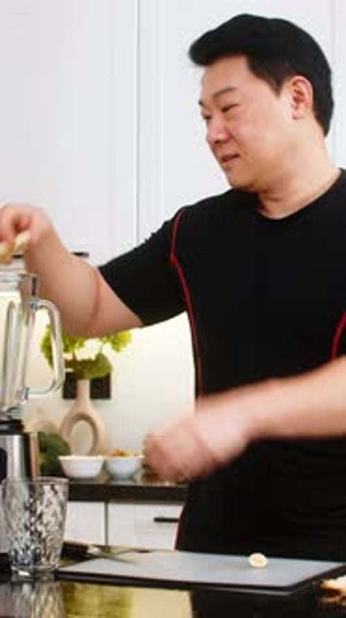 Man Prepares Banana Slices for Smoothie in Kitchen