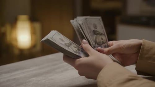 Hands Counting US Hundred Dollar Bills Indoors