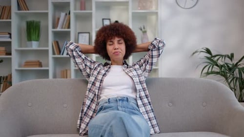 Relaxed Woman Leans Back Contentedly on Sofa