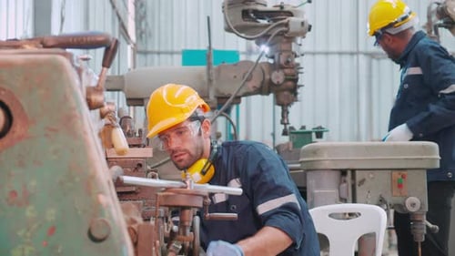 Young caucasian engineer man operating lathe machine for preparing production at factory industrial.
