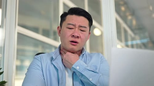 Man Rubs Neck in the Office