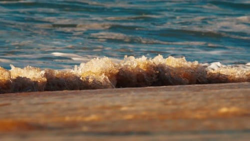 Ocean Wave Breaks on the Shore at Sunrise