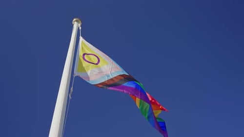 Pride Progress Flag Waving Against Blue Sky Background