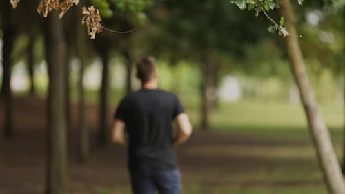 Athletic Man Running in the Park During Morning Workout