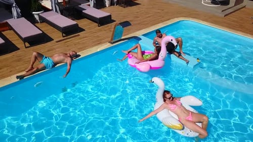 People Relaxing on Floats in Swimming Pool