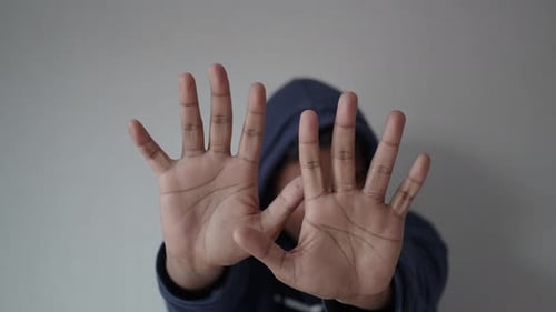 Trauriger Mann mit Kapuze, verdecktes Gesicht mit isolierten Händen, schwarz