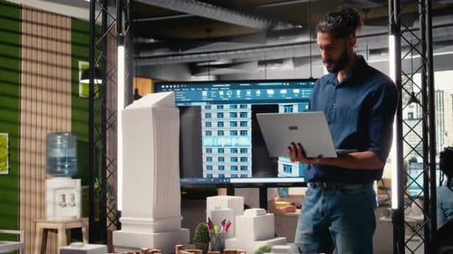 Male Developer Evaluating Architectural 3D Models and Plans