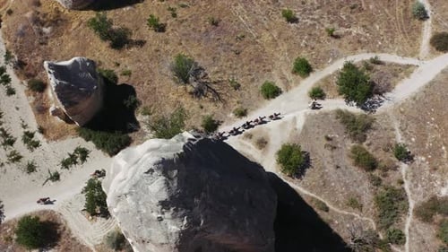 Aerial view of riders with horses walking through the tufa landscape of the UNESCO World Heritage Si