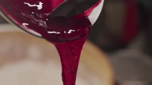 Strawberry jam, red raspberry syrup or beetroot natural dye, viscous fluid close