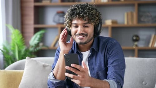 Man Listening to Music on Smartphone at Home