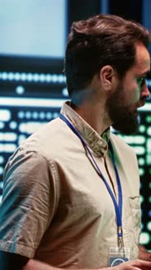 Man Inspects Server Room with Tablet