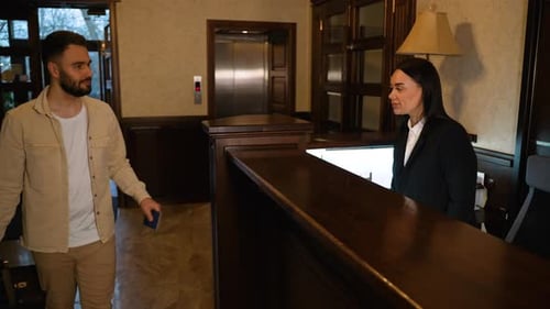 Male Traveler Checking in at Hotel Reception Desk