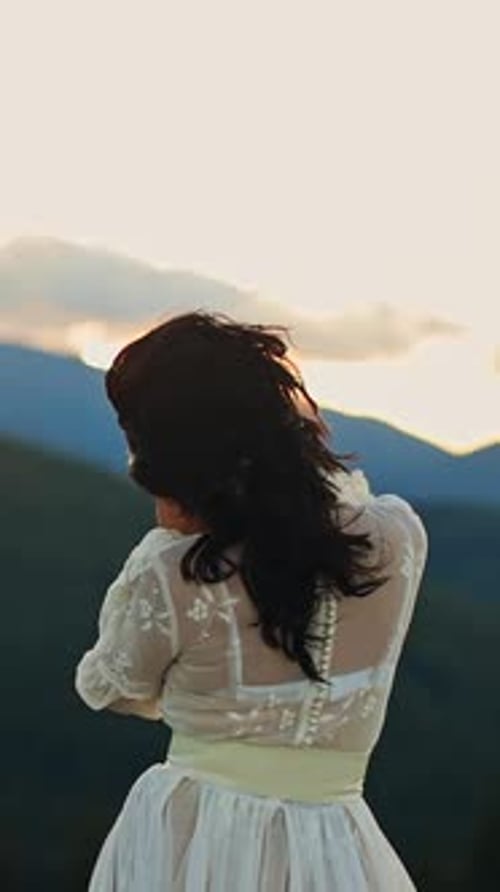 Schönes weibliches Model auf grünen Landschaften. Hübsche Frau in weißem Kleid, die in den Bergen spaziert.