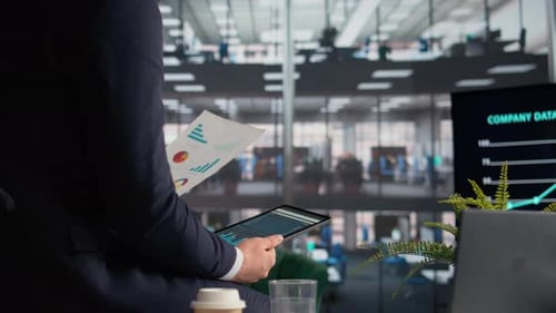 Man Analyzing Data with Tablet in Modern Office