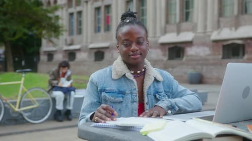 Portrait of African-American Girl with Laptop and Workbooks on Campus