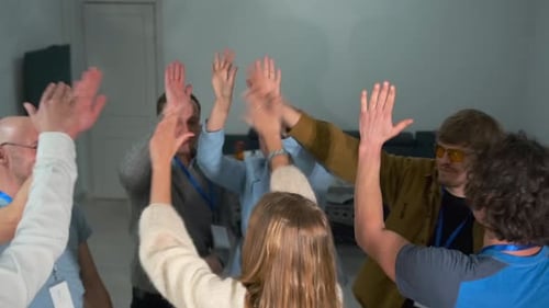 Office Team Celebrating Together with High Fives in a Circle