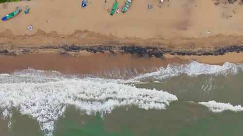 Eine Luftaufnahme von Meereswellen, die auf den Strand prallen.