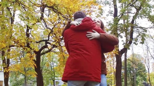 Romantic Couple Embracing Under Colorful Autumn Trees