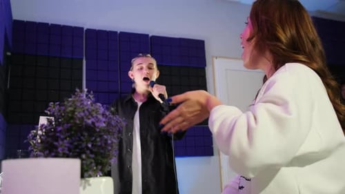 Man Singing With Vocal Coach in Music Studio