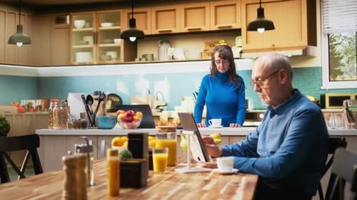 Senior Man Using Tablet with Woman in Kitchen