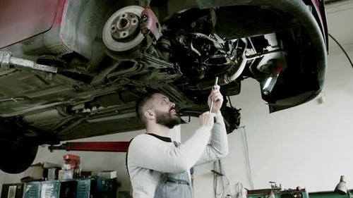 Man Mechanic Repairing a Car in a Garage